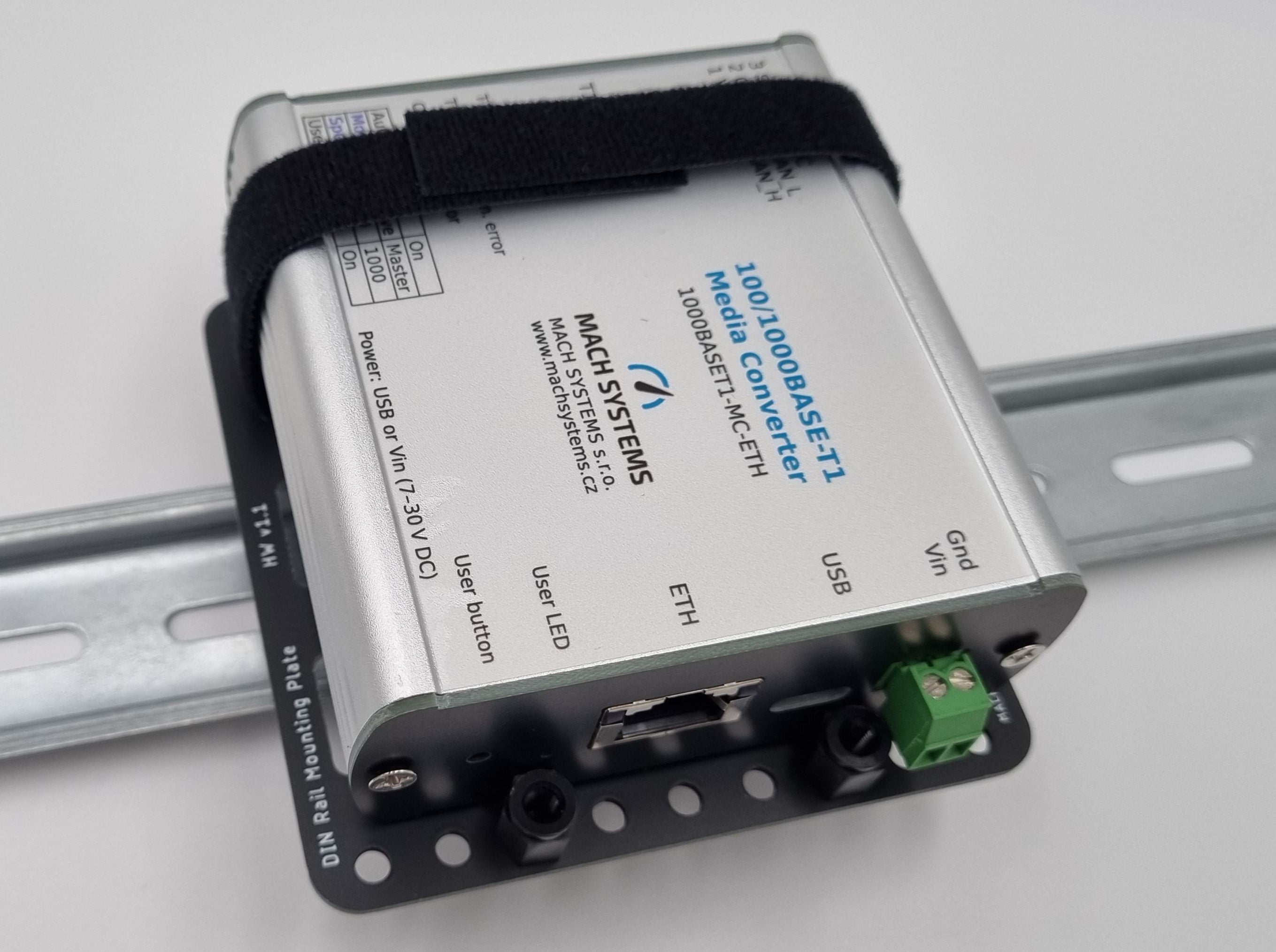 Mach Systems Mounted Universal DIN Rail Bracket, angled front face image with Velcro strapped 100/1000Base-Ti Media Converter view